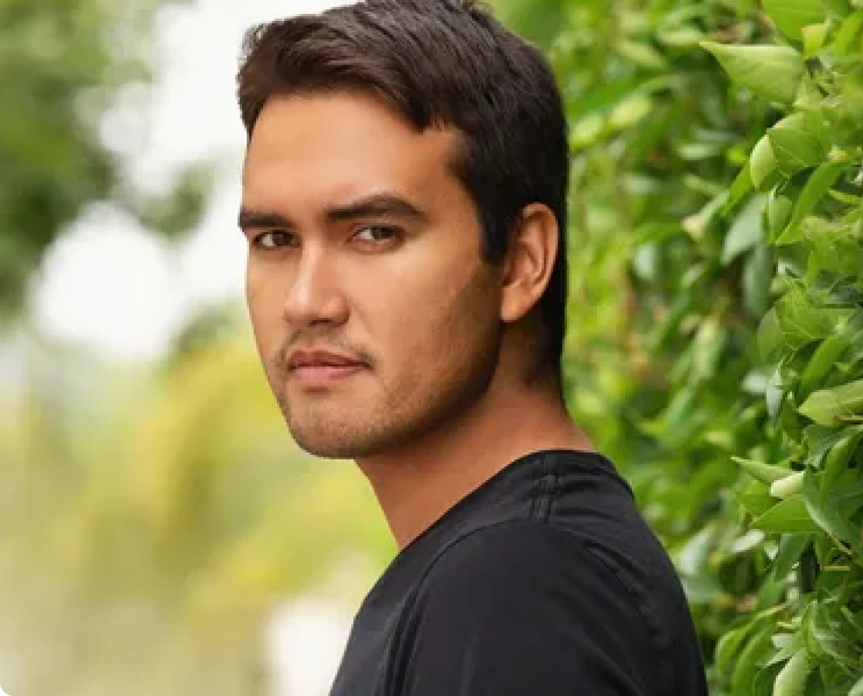 Man standing by green foliage